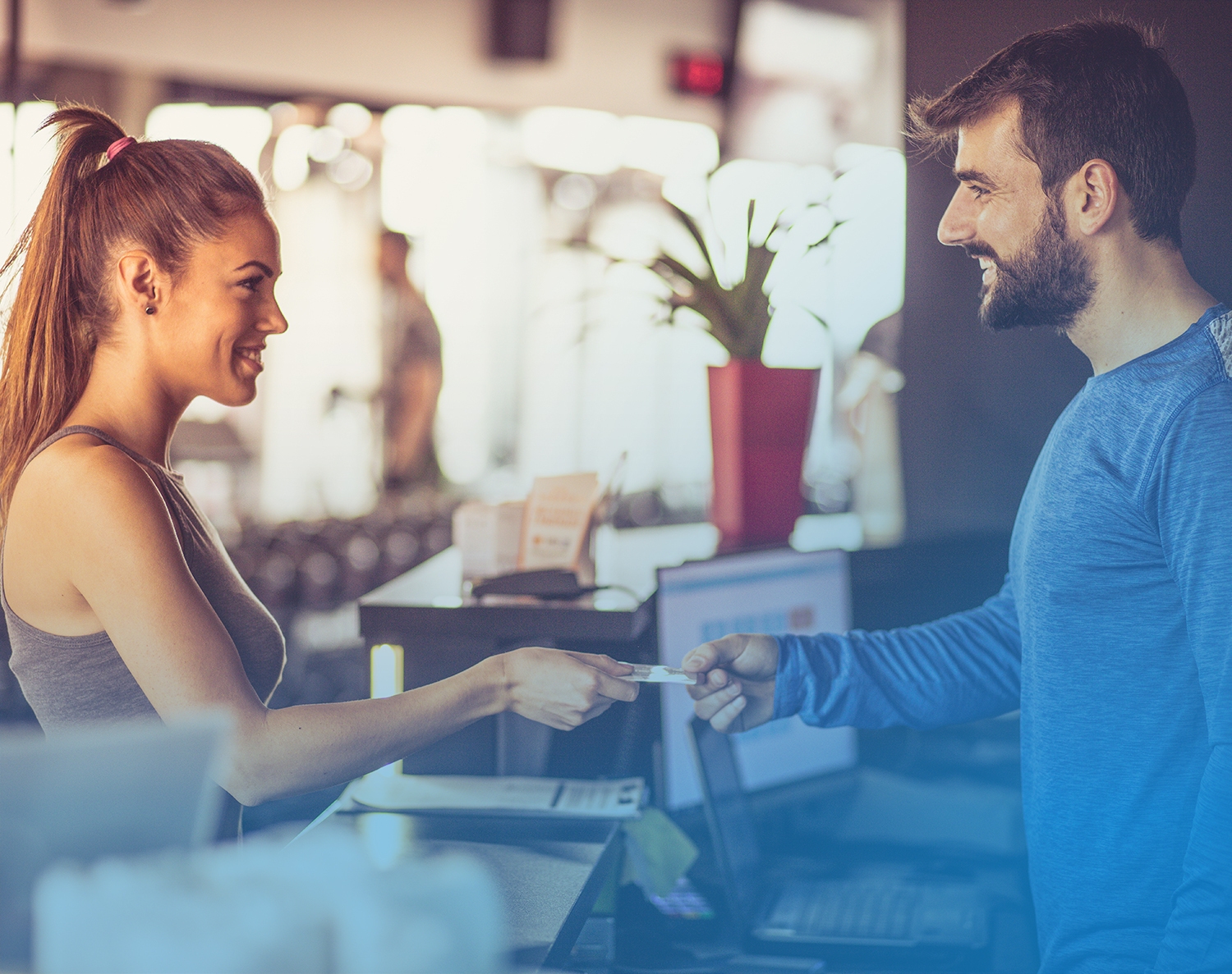 woman paying by card at the gym reception